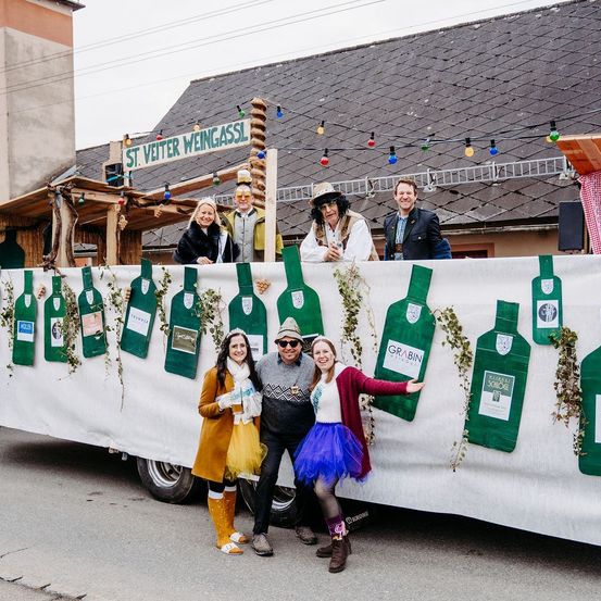 Bild enthält, People, Person, Wheel, Outdoors, Shelter, Coat, Text, Banner, Shoe, Face
