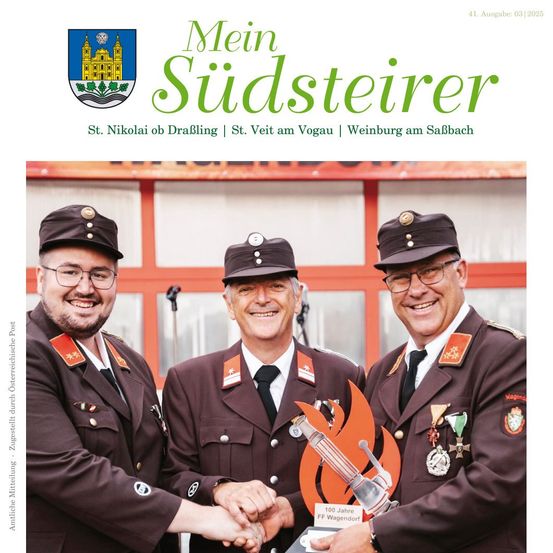 Drei Männer in Militäruniformen stehen vor einem Gebäude und lächeln. Sie halten eine Trophäe mit der Aufschrift '100 Jahre FF Wagendorf'.