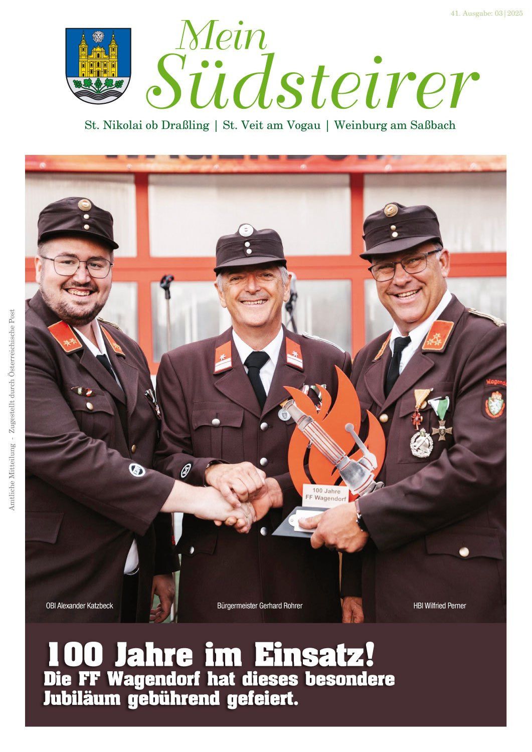 Drei Männer in Uniformen stehen lächelnd nebeneinander, einer von ihnen hält eine Trophäe. Sie stehen vor einem roten Gebäude.