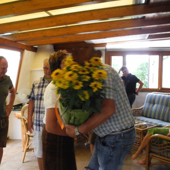 Bild enthält, Couch, Flower, Flower Arrangement, Flower Bouquet, Wood, Pants, Potted Plant, Living Room, Man, Person