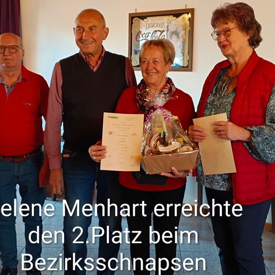 Helena Menhart erreichte den zweiten Platz beim Bezirksschnappsen. Sie hält ein Zertifikat und einen Geschenkkorb.