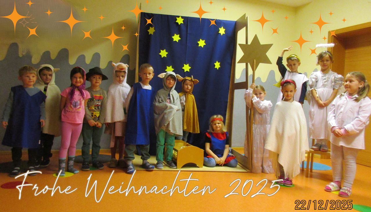 Kinder in verschiedenen Kostümen stehen vor einer Kulisse mit Sternen und einem Holzstern, wahrscheinlich bei einer Weihnachtsaufführung. Das Bild enthält einen Wasserzeichen mit dem Text 'Weihnachten 2025'.