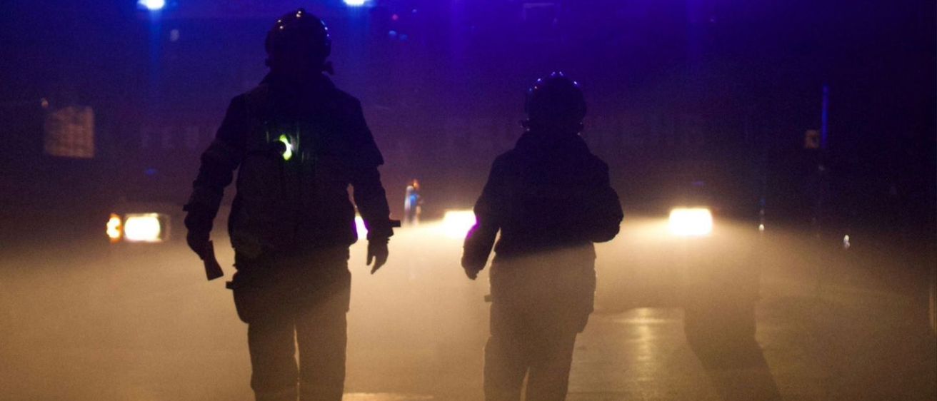 Zwei Feuerwehrleute in Uniformen gehen durch Nebel, Scheinwerfer dahinter. Der Text lautet: 'Bist DU mutig genug, den Unterschied zu machen?' Unten steht: 'Werde jetzt Mitglied!' Weitere Infos gibt es auf unserer Webseite.