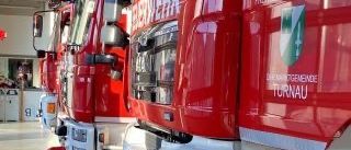 Eine Reihe roter Feuerwehrfahrzeuge in einer Garage geparkt, jedes mit einem Logo und dem Wort Turnau an der Seite.