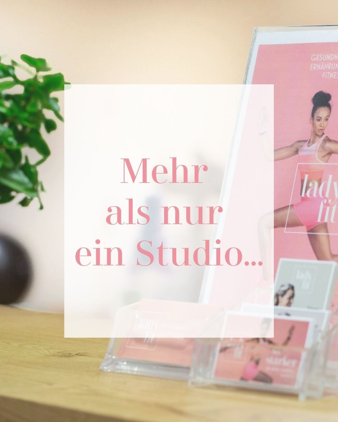 Ein Fitnessmagazin mit einer Frau auf dem Cover, die trainiert. Im Hintergrund ist eine Pflanze und ein Schreibtisch zu sehen. Der Text lautet 'Mehr als nur ein Studio...'.