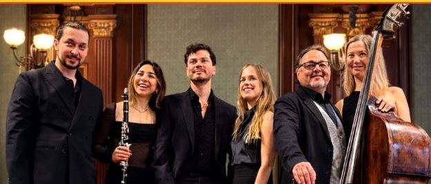 Ein Plakat für ein Latin Ensemble Konzert am 17. April 2026 in Friesach. Es zeigt eine Gruppe von Musikern mit verschiedenen Instrumenten und lächelnd. Die Ticketpreise sind angegeben.