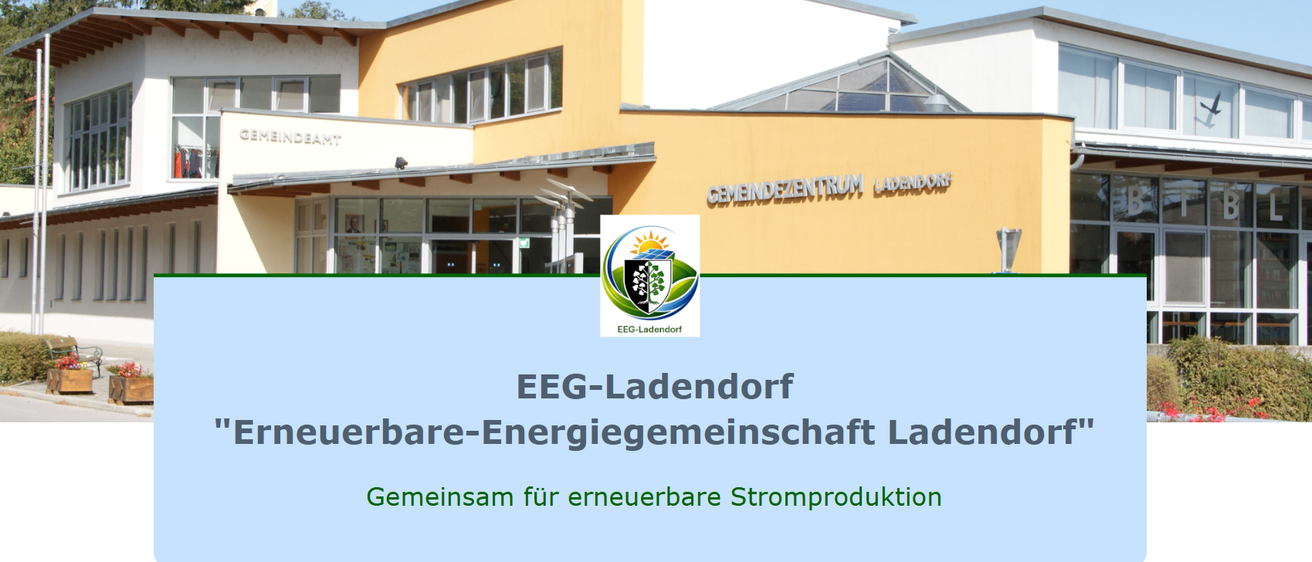 Ein gelbes Gebäude mit einem Glasdach zeigt den Text 'Gemeindzentrum Ladendorf'. Darunter befindet sich ein Logo mit einer Sonne und einem grünen Baum. Der Text 'EEG-Ladendorf' und 'Erneuerbare-Energiegemeinschaft Ladendorf' sind zu sehen, gefolgt von 'Gemeinsam für erneuerbare Stromproduktion.'