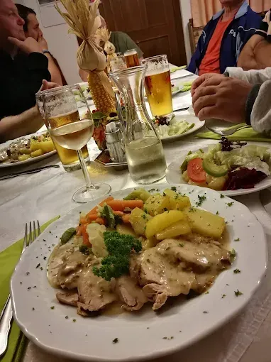 Ein Tisch ist für eine Mahlzeit mit mehreren Tellern mit Essen, Getränken und Besteck gedeckt.