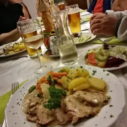 Ein Tisch ist für eine Mahlzeit mit mehreren Tellern mit Essen, Getränken und Besteck gedeckt.