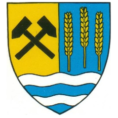Das Wappen zeigt einen blau-gelben Schild mit gekreuzten schwarzen Hämmern im oberen Teil und drei Weizengarben auf der rechten Seite. Unten befindet sich eine blau-weiße Wellenlinie.