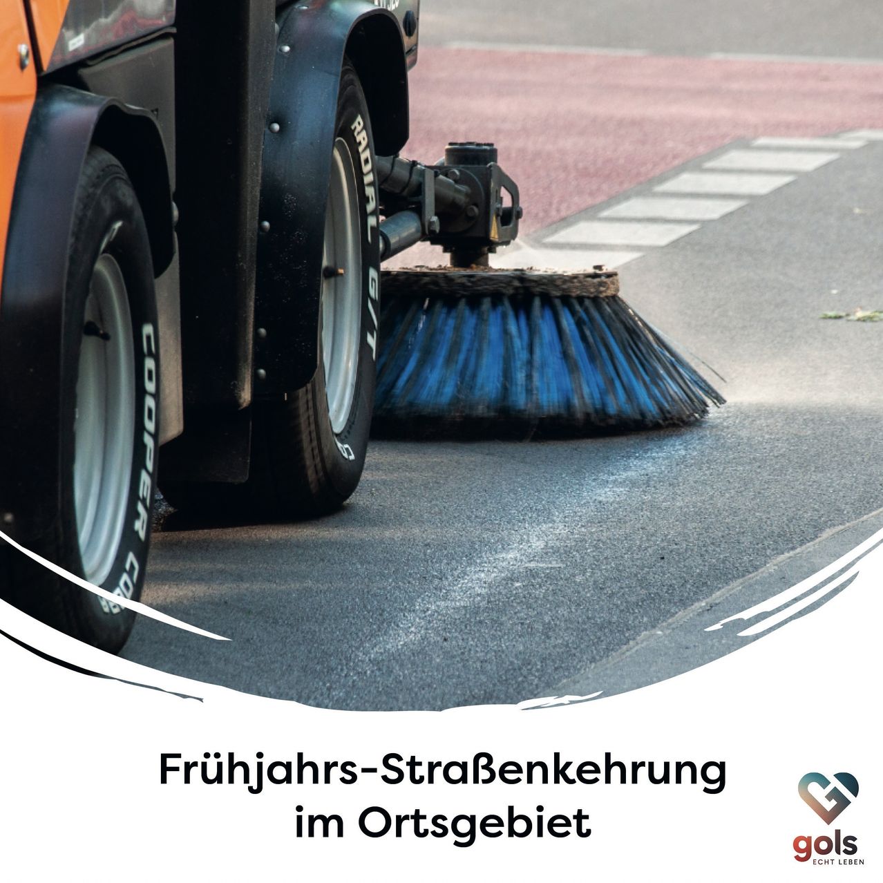 Ein Straßenreinigungsfahrzeug mit einer großen blauen Bürste steht auf der Straße und reinigt das Gebiet. Das Fahrzeug hat ein auffälliges Markenlogo an der Seite.