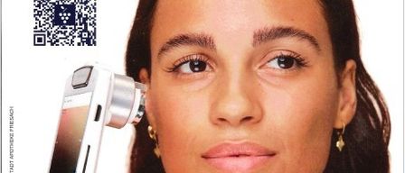 Eine Frau benutzt ein weißes Dermatoskop an ihrem Gesicht und schaut direkt in die Kamera, mit einem QR-Code in der oberen linken Ecke und dem Markennamen Caudalie über ihr.