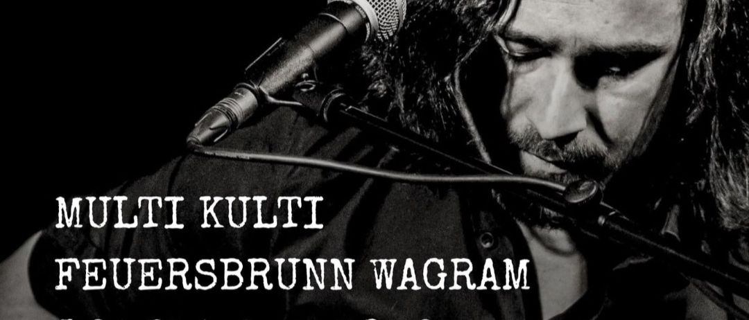 Ein Schwarz-Weiß-Foto eines Mannes, der eine Gitarre spielt und in ein Mikrofon singt. Der Text lautet 'Solo - Unplugged', 'Tantra Blues und andere Songs' und 'Multi Kulti Feuersbrunn Wagram'. Das Datum und die Uhrzeit der Veranstaltung sind ebenfalls angegeben.