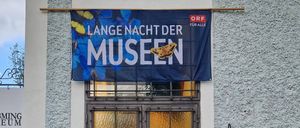 Der Eingang des Grobming Museums mit einer geschlossenen Glastür und einer Holzstatue. Ein blaues Banner mit der Aufschrift Lange Nacht der Museen.