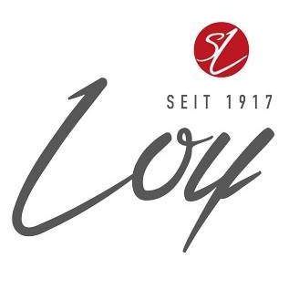Das Logo für Loy, eine Marke seit 1917, zeigt den Schriftzug 'Loy' in kursiver Schrift mit einem roten Kreis, der den Buchstaben 'L' enthält, darüber. Der Text 'SEITE 1917' steht in Großbuchstaben darunter.