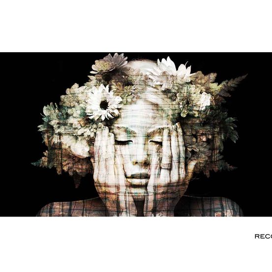 Ein surreales Porträt einer Frau mit einer Blumenkrone auf dem Kopf. Ihr Gesicht ist mit Händen bedeckt, und ihre Augen sind geschlossen. Der Hintergrund ist schwarz, und das Bild hat einen verschwommenen Effekt.