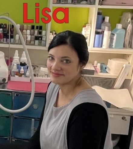 Eine Frau namens Lisa ist in einem Raum, lächelt, mit Regalen voller Nagellack und anderen Schönheitsprodukten im Hintergrund.
