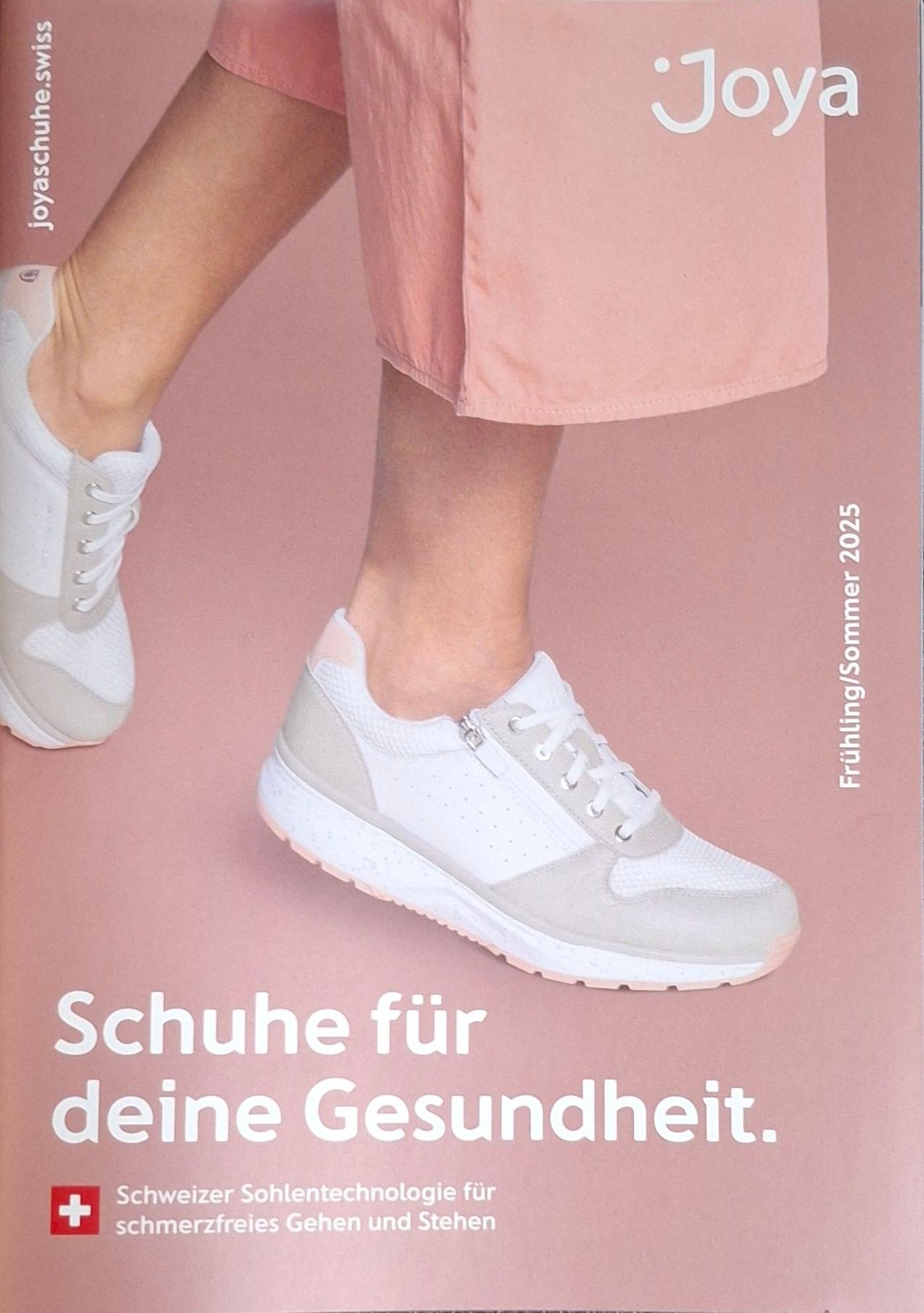 Eine Werbung für Joy-Schuhe, die ein Paar weiße Sneaker mit grauen Akzenten auf einem rosa Hintergrund zeigt. Der Text lautet 'Schuhe für deine Gesundheit'.