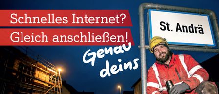 A construction worker leans on a pole at night. A street sign reads St. Ann and a road sign reads Schnelles Internet. The sign reads, Schnelles Internet? Ich anschließen! Genau deins. There is a house under construction.