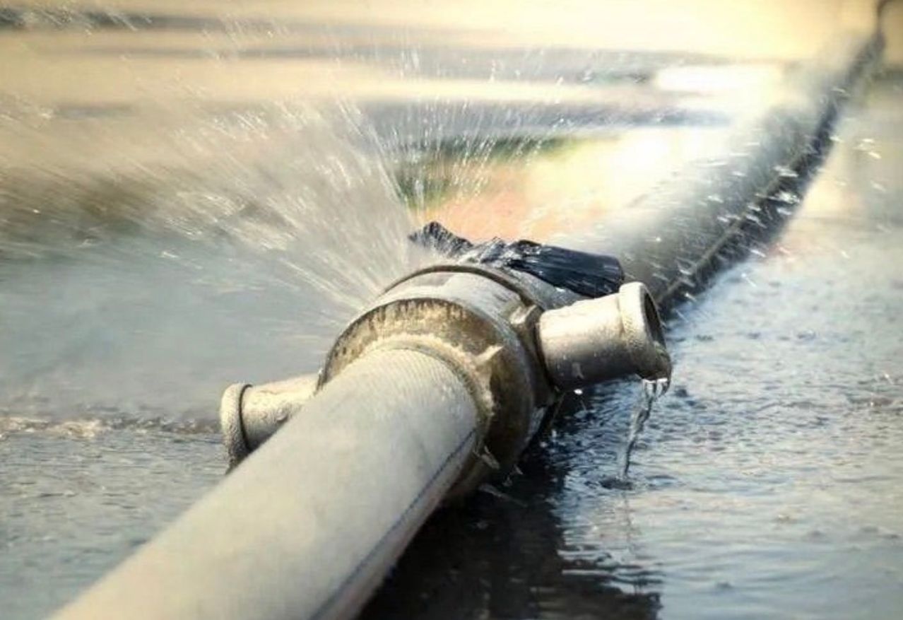 Eine Wasserleitung mit einem Ventil ist undicht und sprüht Wasser in die Luft.