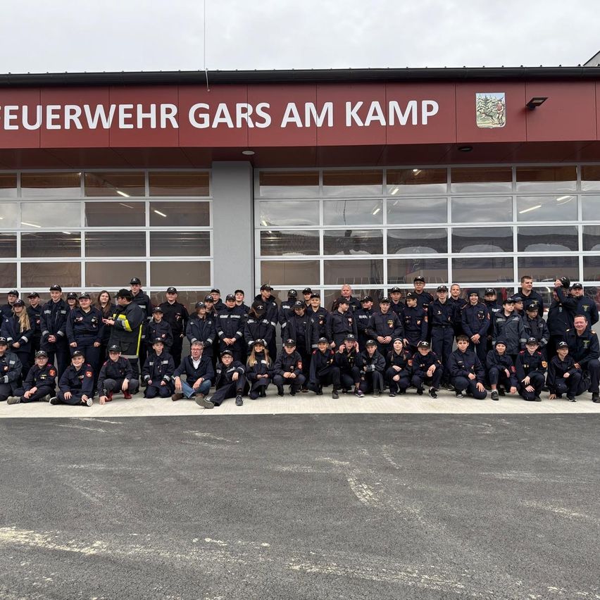 Eine Gruppe Feuerwehrleute und Freiwillige posieren für ein Foto vor der Feuerwehrstation Gars am Kamp.