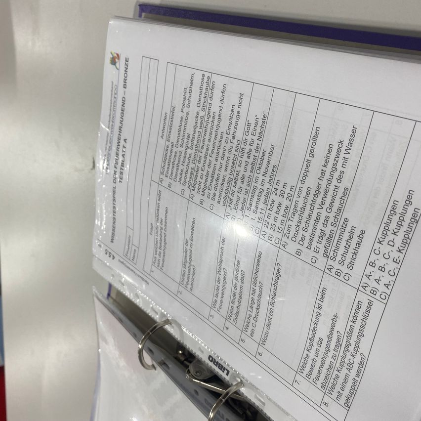 Ein Dokument mit dem Titel 'WISSENSTÜCKE FRÜHREIFEUNG TESTBLATT A BRONZE' wird in einem Ordner gehalten. Es enthält verschiedene medizinische und persönliche Details, wie Messungen, Gewichte und Daten. Das Dokument scheint eine medizinische Aufzeichnung oder Entwicklungsbewertung zu sein.