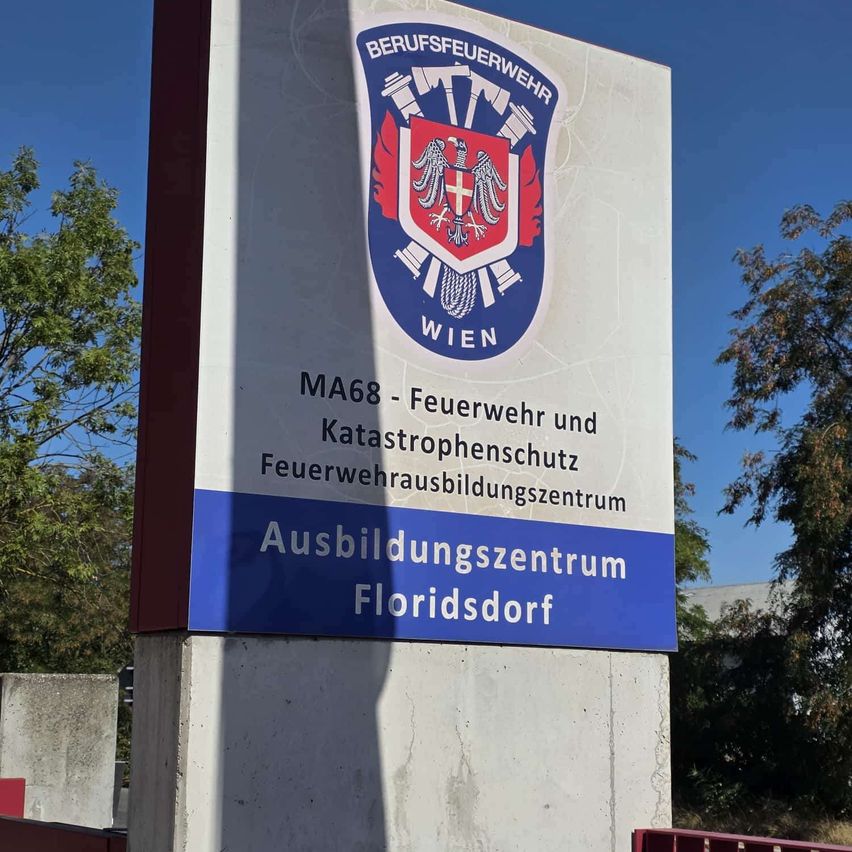 Ein Schild für das MA68 Feuerwehr- und Katastrophenschutz-Ausbildungszentrum in Floridsdorf, Wien, mit einem Wappen und dem Text 'MA68 - Feuerwehr und Katastrophenschutz'.