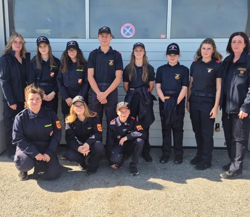 Eine Gruppe von Frauen in Uniform posiert für ein Foto vor einem Gebäude.