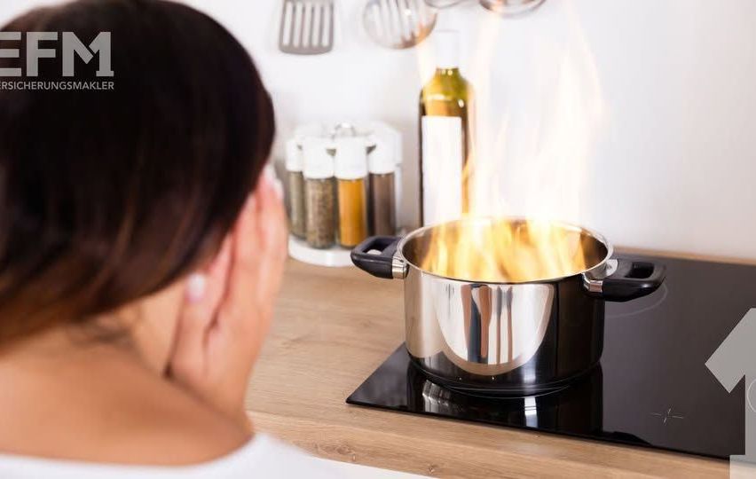 Eine Frau in einer Küche schaut auf einen Topf mit Flammen auf einem schwarzen Herd.