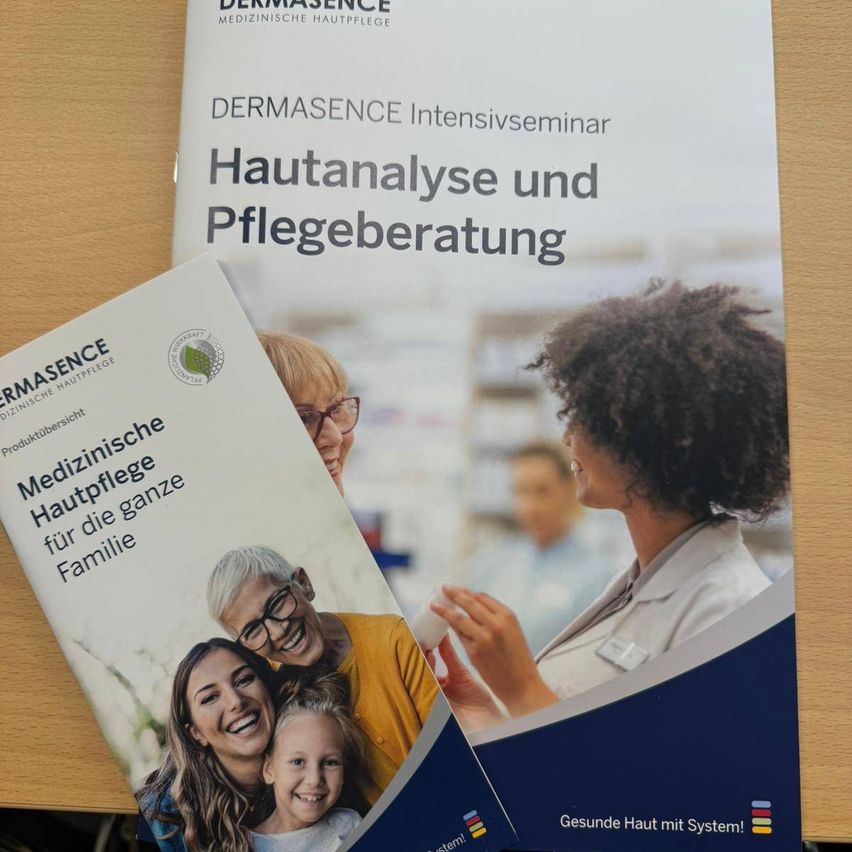 Zwei Bücher liegen auf einer Holzoberfläche. Eins heißt 'Dermasence Intensivseminar Hautanalyse und Pflegeberatung'. Das andere heißt 'Medizinische Hautpflege für die ganze Familie'. Eine Frau ist in einer Apotheke.