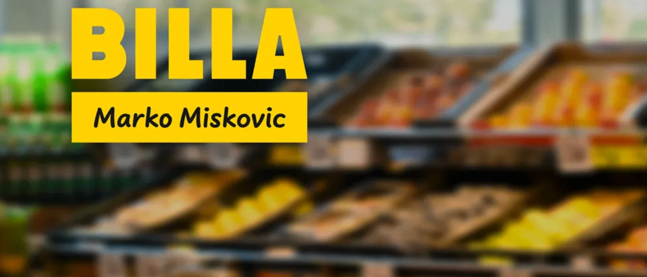 Ein Bild zeigt ein gelbes Schild mit weißem Text, das 'LLA' über einem unscharfen Hintergrund von Lebensmitteln liest, möglicherweise in einer Ladenumgebung.