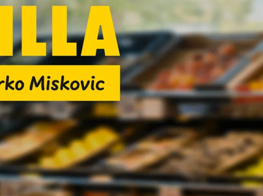 Ein Bild zeigt ein gelbes Schild mit weißem Text, das 'LLA' über einem unscharfen Hintergrund von Lebensmitteln liest, möglicherweise in einer Ladenumgebung.