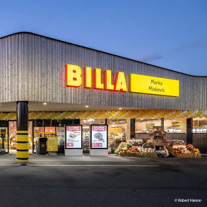 Ein BILLA-Laden mit gelben Schildern und Luftballons. Extreme Aktion-Schilder sind davor.