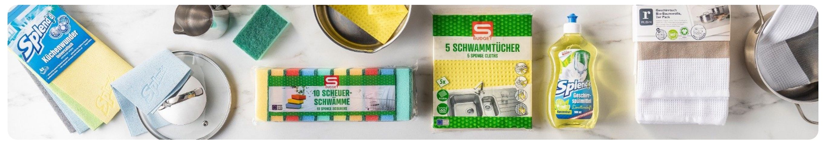 Packungen mit Schwammtüchern und Scheuerschwämmen auf einer weißen Oberfläche. Eine Packung hat 10 Scheuerschwämme, die andere hat 5 Schwammtücher.