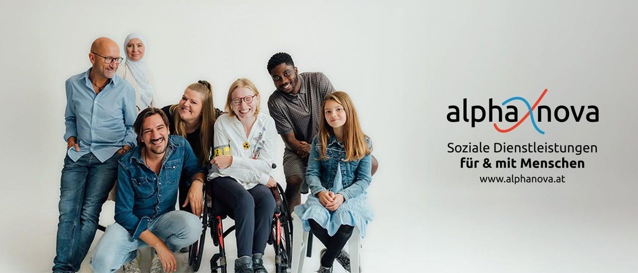 A group of people, including two women in wheelchairs, are smiling and posing for a photo against a white background. The text 'alp Sozial für' is visible in the bottom right corner.