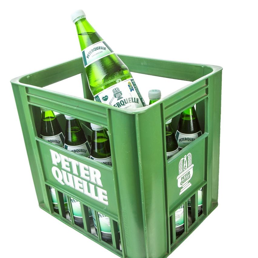 Ein grüner Kasten gefüllt mit Peter Quelle Mineralwasserflaschen, wobei eine Flasche aufrecht oben steht.