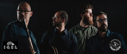 Vier Musiker stehen zusammen und halten jeweils ein Musikinstrument. Der Mann auf der linken Seite hält eine Flöte, der Mann in der Mitte hält eine Gitarre und der Mann auf der rechten Seite hält eine Klarinette.