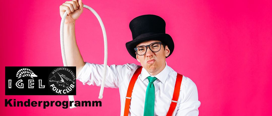 Ein Mann, der ein weißes Hemd, eine grüne Krawatte und rote Hosenträger trägt, einen schwarzen Zylinder trägt, ein Seil hält und einen überraschten Gesichtsausdruck macht.