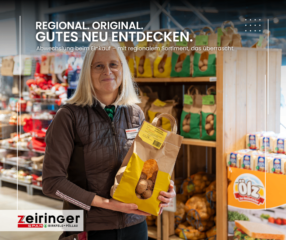 Eine Frau in einer braunen Jacke hält einen gelben Kartoffelbeutel in einem Supermarkt. Die Regale hinter ihr sind mit verschiedenen Produkten bestückt. Der Slogan des Ladens lautet 'Regional. Original. Gutes Neu Entdecken.'