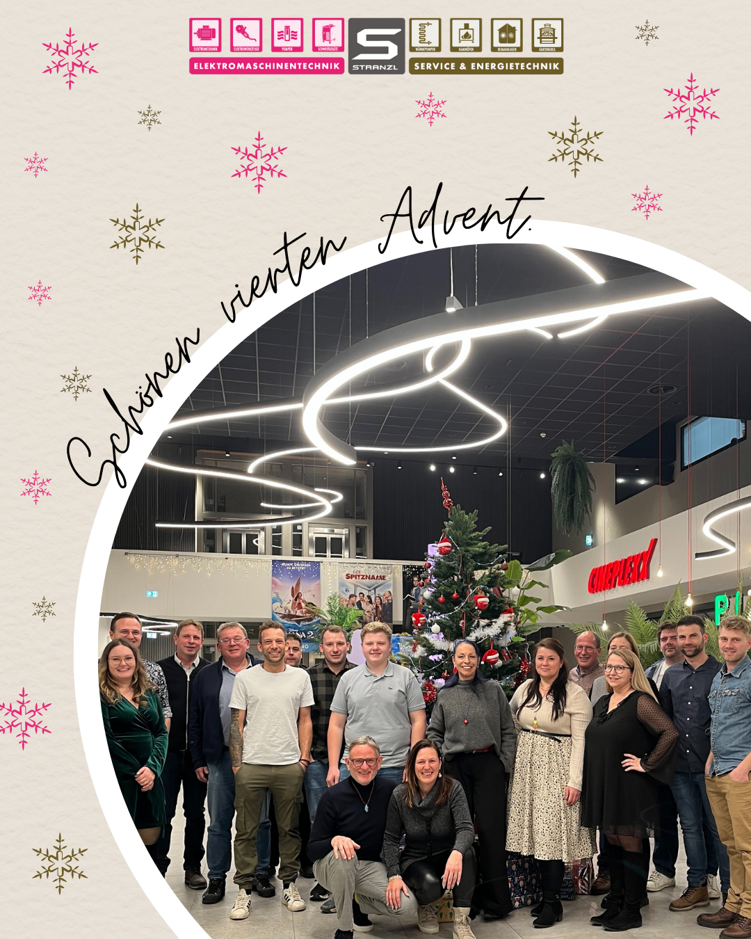 Eine Gruppe von Menschen steht um einen Weihnachtsbaum in einem Einkaufszentrum, mit dekorativen Schneeflocken und Lichtern. Sie lächeln für ein Foto, mit den Worten 'Zählen wir zum Advent' im Hintergrund.