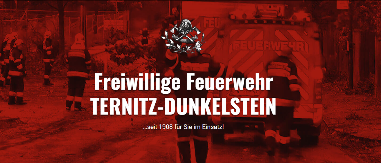 Ein rotes Plakat mit dem Text Freiwillige Feuerwehr Ternitz-Dunkelstein. Das Plakat hat ein Logo eines Feuerwehrmanns. Der Feuerwehrmann trägt einen Helm und einen Feuerlöscher. Das Plakat hat einen roten Hintergrund.