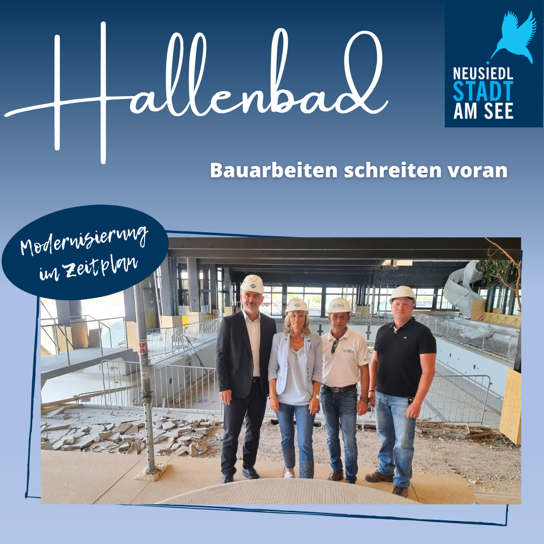 Vier Personen stehen auf einer Baustelle. Drei Männer und eine Frau. Sie tragen Helme und Freizeitkleidung. Hinter ihnen steht ein Gebäude im Bau.