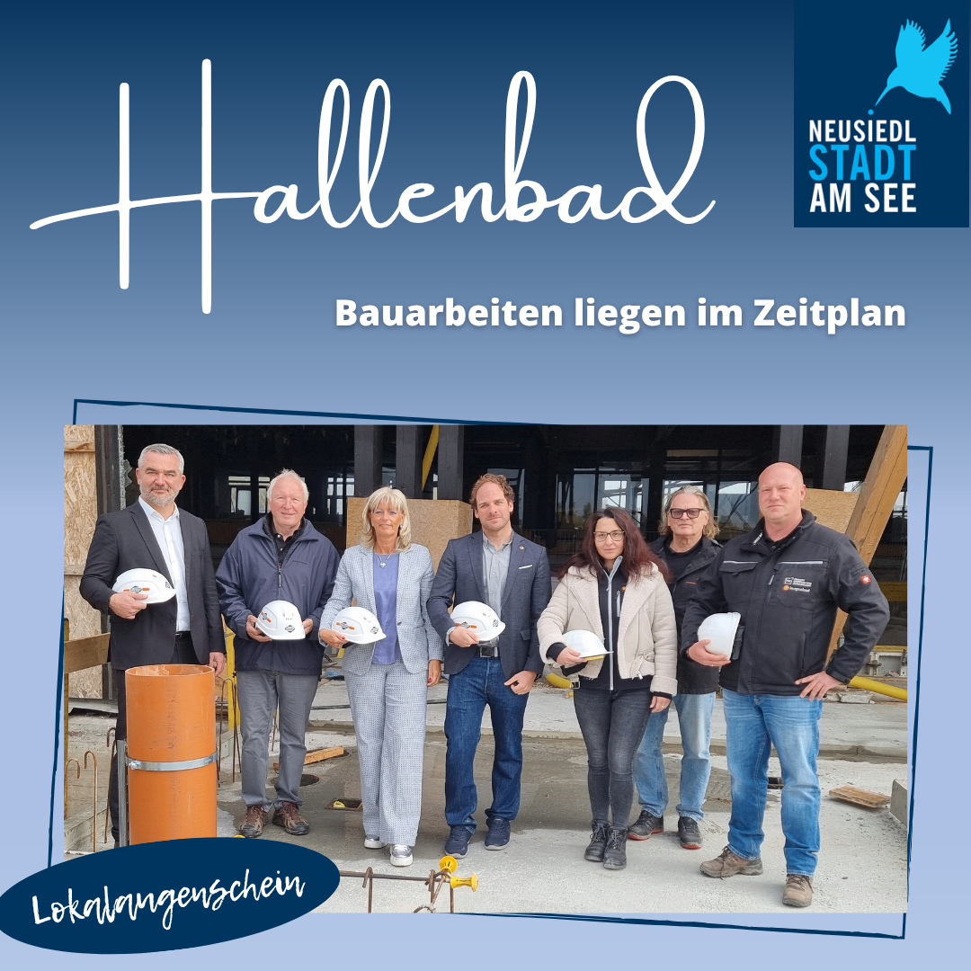 Die Bauarbeiten liegen im Zeitplan. Sieben Personen stehen vor einem Gebäude. Sie tragen alle Helme und Jacken. Rechts oben befindet sich ein blaues Logo mit einem Vogel.