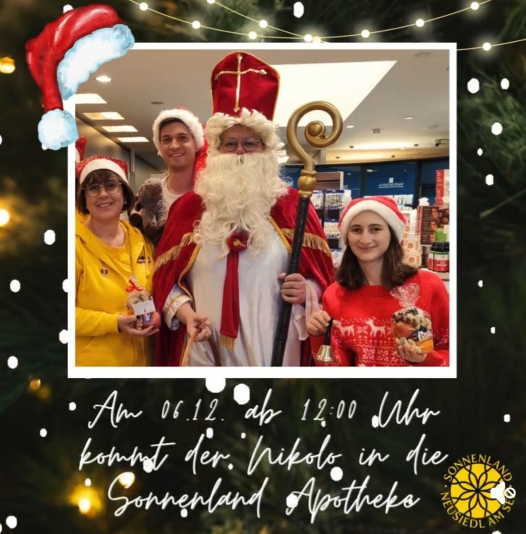 Ein Foto von Santa Claus mit einer Gruppe von Menschen in einer Apotheke. Santa hält einen Stab und lächelt. Das Datum und die Uhrzeit auf dem Bild sind 06.12 um 12:00. Das Bild hat ein Weihnachtsthema.