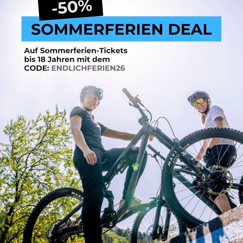 A 50% discount on summer holiday tickets for up to 18 years with the code ENDLICHFERIEN26. Two people are riding bikes outdoors, wearing helmets. Trees and bushes are in the background.