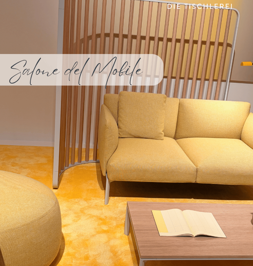 Ein gelbes Sofa mit Kissen steht in einem Wohnzimmer mit einem Holztisch und einem offenen Buch. Der Raum ist mit einem gelben Teppich und einer hölzernen Trennwand ausgestattet.