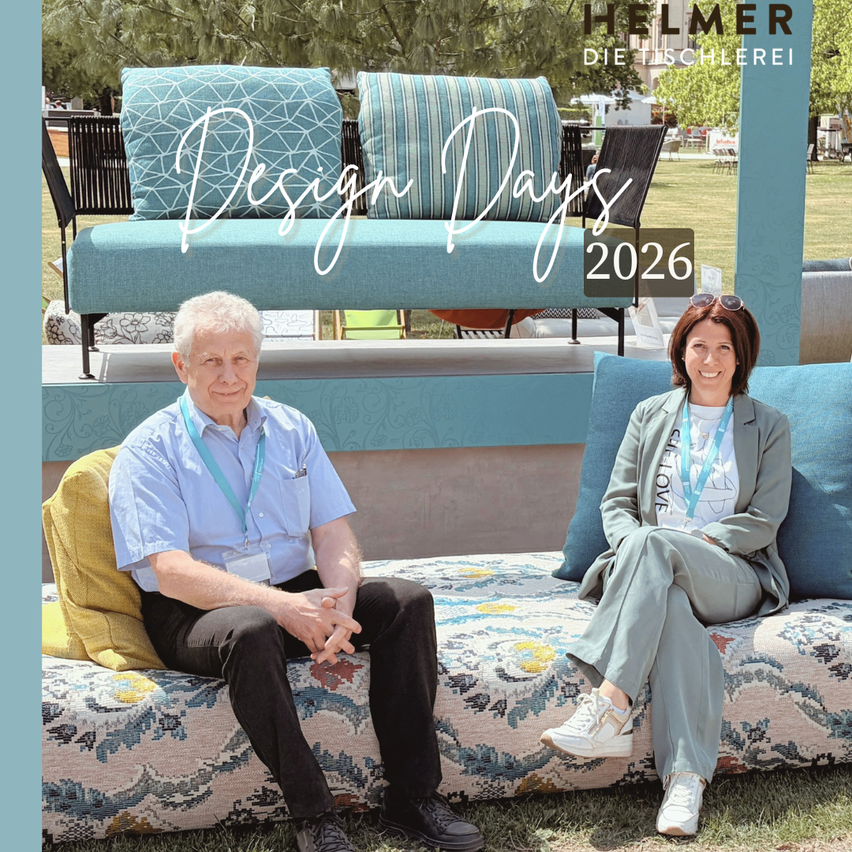 Ein Mann und eine Frau sitzen auf einem gemusterten Sofa im Freien. Der Mann trägt ein blaues Hemd, die Frau ein weißes. Beide tragen Ausweise. Der Text lautet Design Days 2026.