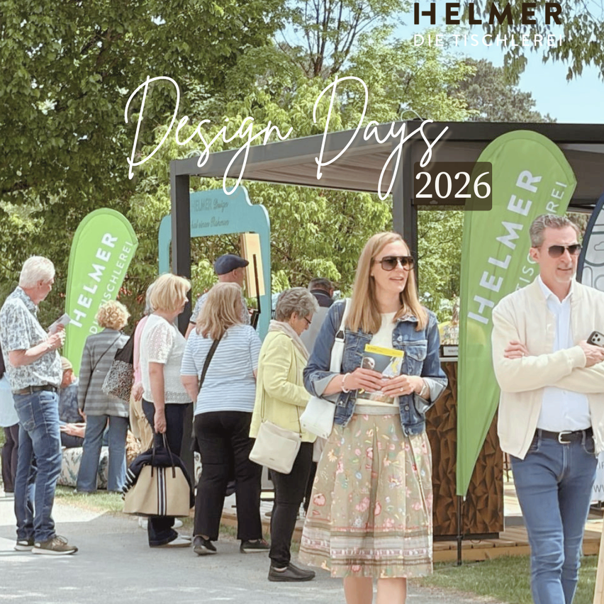Eine Outdoor-Veranstaltung mit Menschen, die stehen und ein Banner, das Design Days 2026 sagt. Es gibt auch zwei Männer vor einem Stand.
