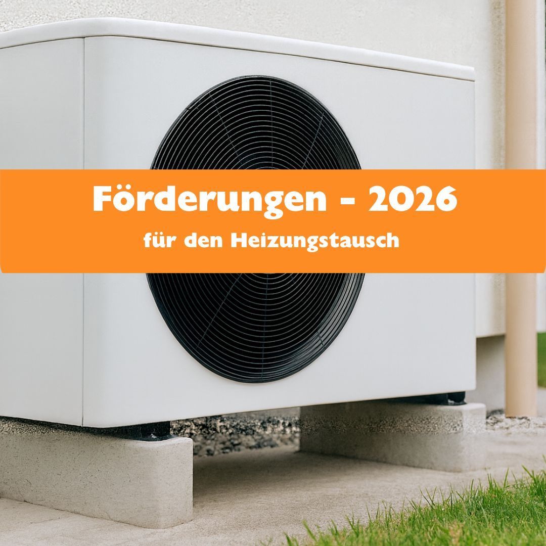 Ein Klimaanlagengerät ist auf Betonblöcken an einem sonnigen Tag installiert. Das Gerät ist weiß und hat einen schwarzen Lüfter. Es gibt eine Textüberlagerung mit der Aufschrift 'Förderungen - 2026 für den Heizungstausch.' Die Wand hinter dem Gerät ist weiß.