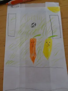 Eine Zeichnung auf Papier zeigt zwei lächelnde Karotten in einem Grasfeld mit einem Fußball im Hintergrund.